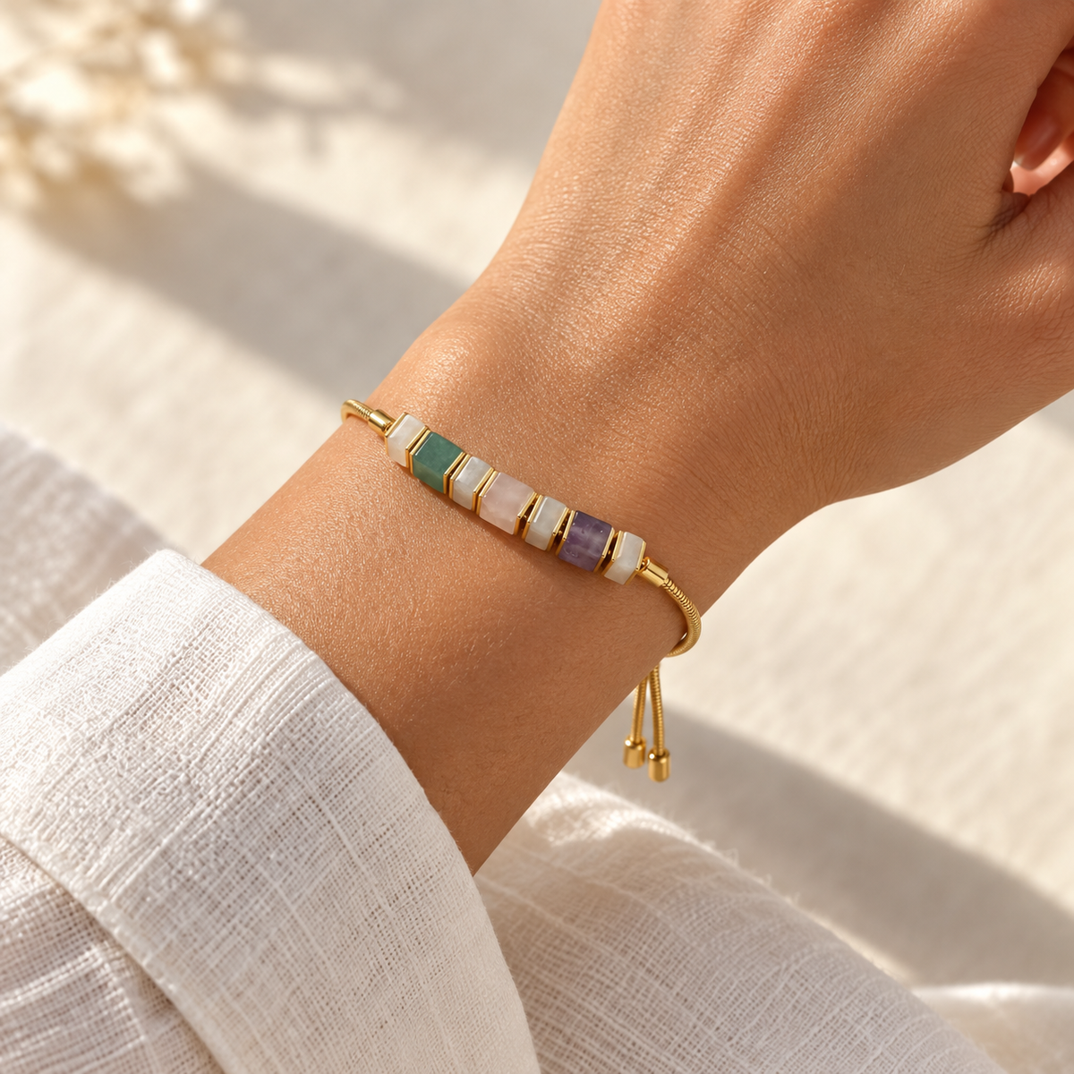Adjustable natural stone bracelet shown worn on a wrist beside a white linen sleeve